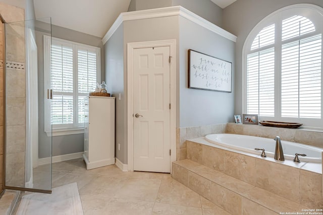 bathroom with vaulted ceiling, tile patterned flooring, a garden tub, and tiled shower