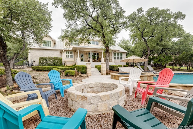 view of patio / terrace with an outdoor fire pit and an outdoor pool