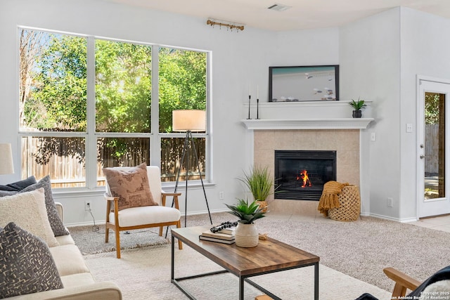 20437 Wild Spgs, San Antonio, TX 78258 - carpeted living area featuring a tiled fireplace, baseboards, and visible vents