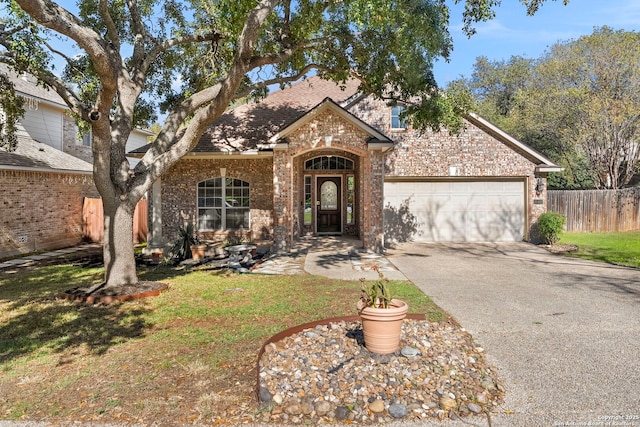 20437 Wild Spgs, San Antonio, TX 78258 - view of front of home with a garage, fence, a front yard, brick siding, and driveway