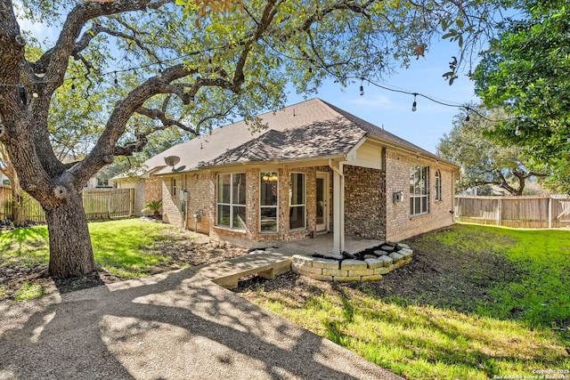 20437 Wild Spgs, San Antonio, TX 78258 - back of house featuring a yard, a patio area, brick siding, and a fenced backyard