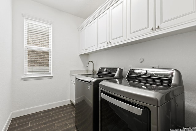 laundry room with washer and dryer, baseboards, dark wood finished floors, and cabinet space