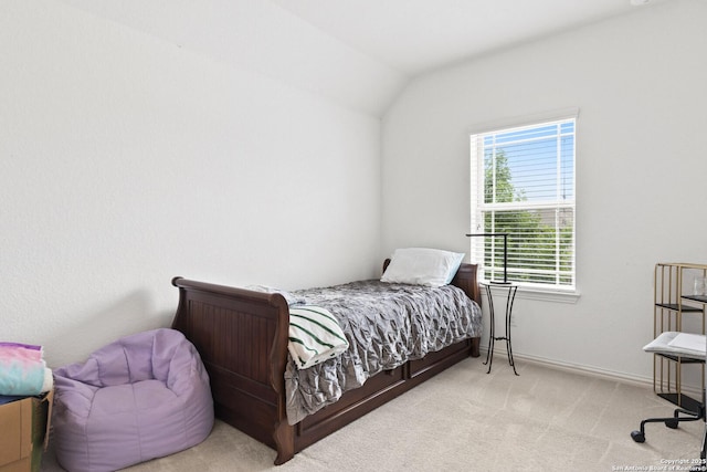 carpeted bedroom with vaulted ceiling and baseboards
