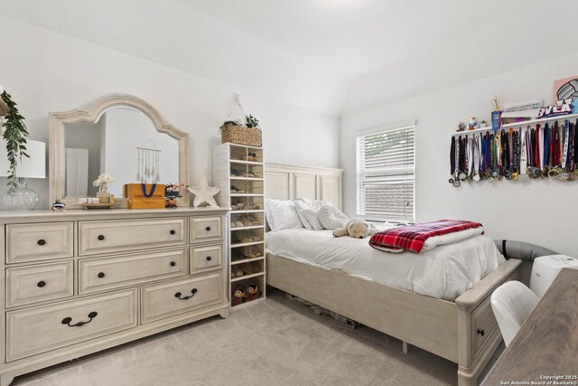 bedroom with light carpet and lofted ceiling