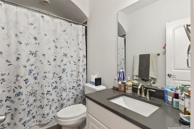 full bathroom featuring toilet, vanity, and a shower with shower curtain