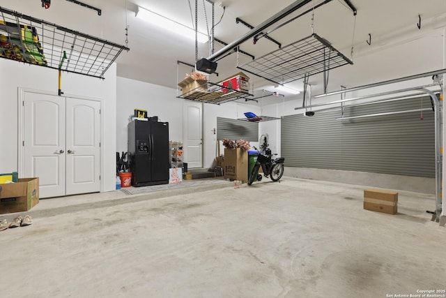 garage with black fridge and a garage door opener