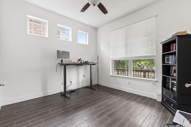 unfurnished office featuring plenty of natural light, a ceiling fan, dark wood-style flooring, and baseboards