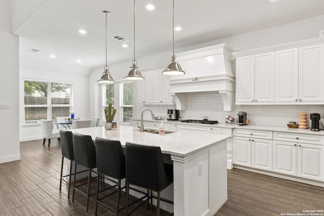 kitchen featuring a sink, decorative backsplash, dark wood-type flooring, stainless steel gas cooktop, and recessed lighting