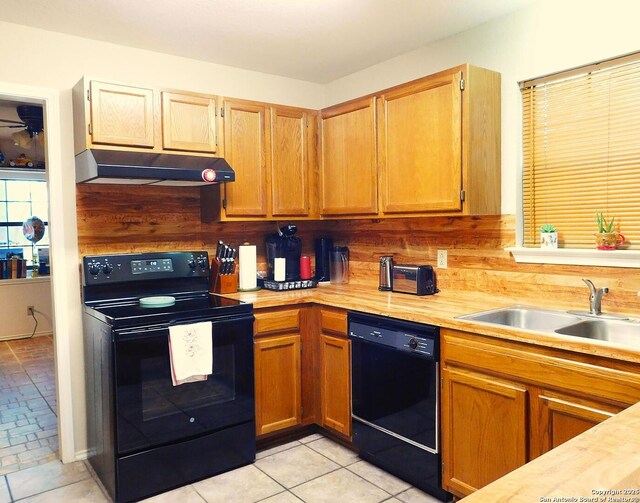 525 Cherry Rdg, Floresville, TX 78114 - kitchen with black appliances, under cabinet range hood, a sink, and light countertops