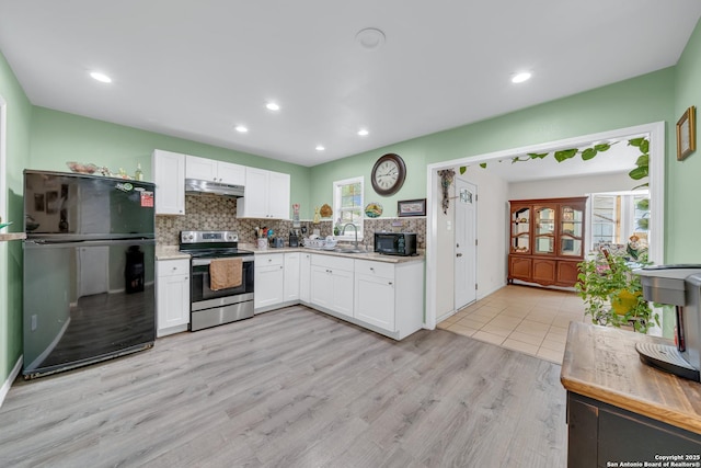 5118 War Cloud, San Antonio, TX 78242 - kitchen featuring black appliances, under cabinet range hood, light countertops, white cabinetry, and decorative backsplash