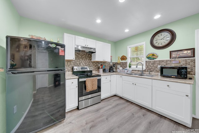 5118 War Cloud, San Antonio, TX 78242 - kitchen with black appliances, a sink, under cabinet range hood, light wood-style floors, and white cabinetry