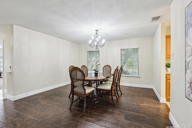 dining room with a chandelier, dark wood-style floors, baseboards, and a textured ceiling