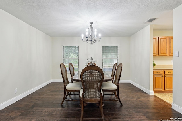 dining space featuring a chandelier, dark wood-style floors, baseboards, and a textured ceiling