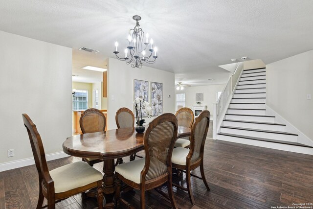 dining area featuring a chandelier, stairs, dark wood finished floors, ceiling fan, and baseboards