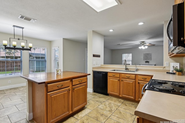 kitchen featuring dishwasher, a sink, light countertops, a ceiling fan, and brown cabinetry
