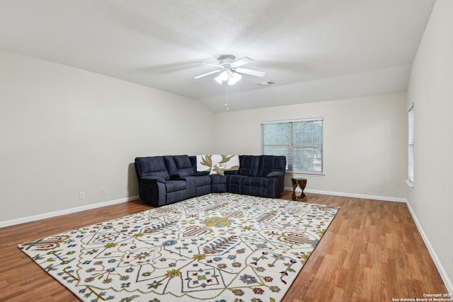 living area featuring wood finished floors, a ceiling fan, and baseboards