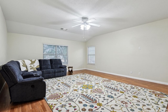 living area featuring a ceiling fan, wood finished floors, lofted ceiling, and baseboards