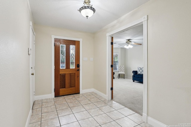 entrance foyer featuring plenty of natural light, baseboards, light tile patterned flooring, and a ceiling fan