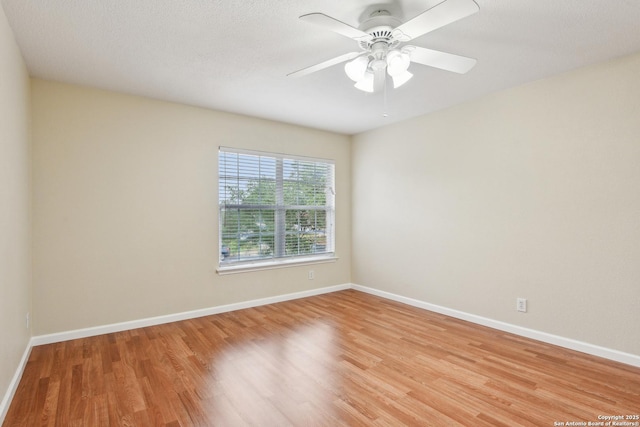 unfurnished room featuring light wood-style flooring, baseboards, and a ceiling fan
