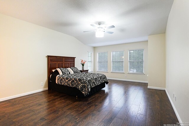 bedroom with dark wood-style floors, baseboards, lofted ceiling, and a ceiling fan