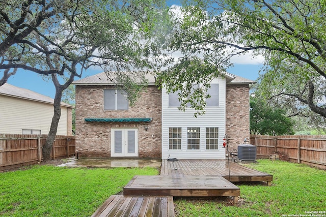 rear view of house featuring french doors, a deck, cooling unit, and brick siding