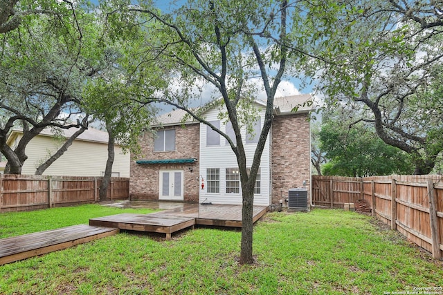 back of property with brick siding, cooling unit, a wooden deck, and french doors