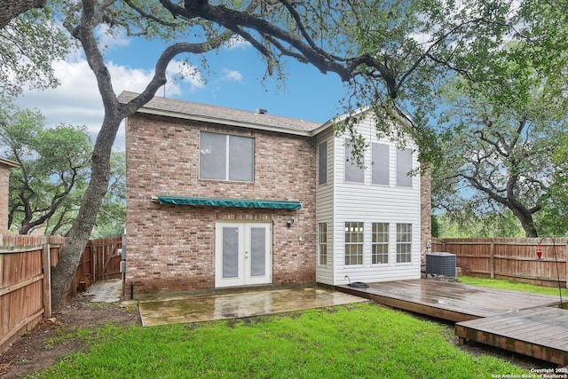 rear view of house with french doors, brick siding, central AC, a wooden deck, and a patio