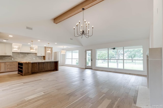 7335 Scintilla Ln, Boerne, TX 78015 - unfurnished living room with beamed ceiling, high vaulted ceiling, light wood-style floors, a sink, and a chandelier