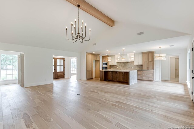 7335 Scintilla Ln, Boerne, TX 78015 - kitchen featuring open floor plan, backsplash, a chandelier, beam ceiling, and light wood-type flooring