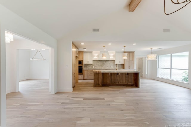 7335 Scintilla Ln, Boerne, TX 78015 - kitchen with custom range hood, light wood-style flooring, beam ceiling, light countertops, and backsplash