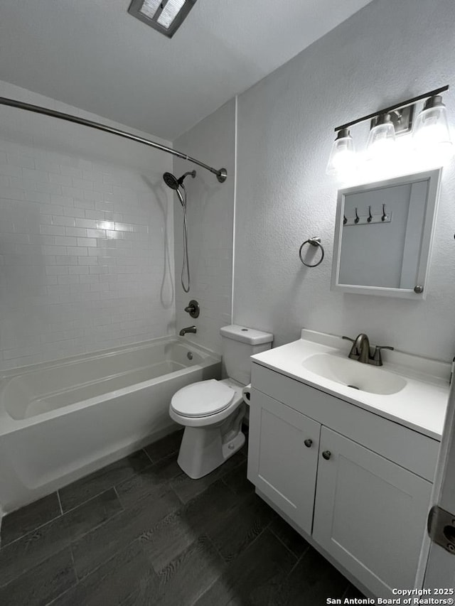 bathroom featuring toilet, vanity, and bathing tub / shower combination