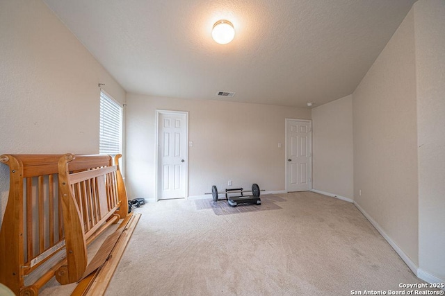 unfurnished bedroom featuring carpet flooring, baseboards, and a textured ceiling