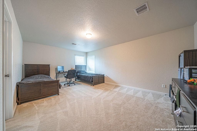 bedroom with light carpet, a textured ceiling, baseboards, and a textured wall