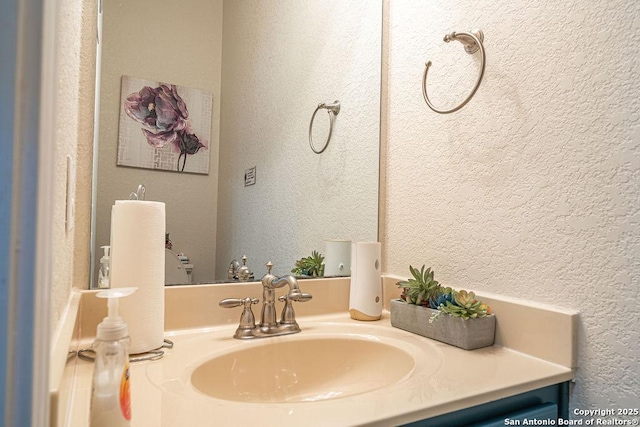 bathroom featuring a textured wall and vanity