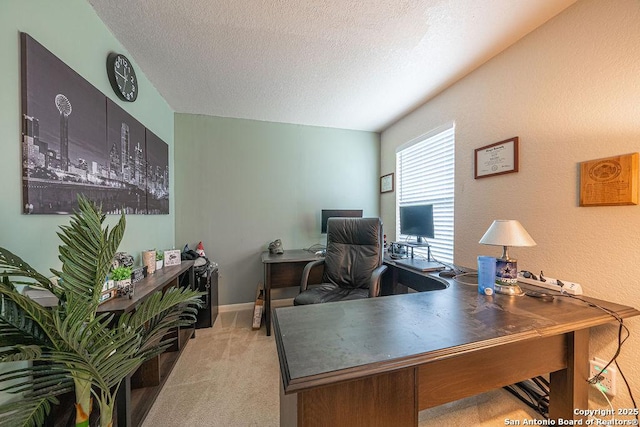 carpeted home office with a textured ceiling and baseboards