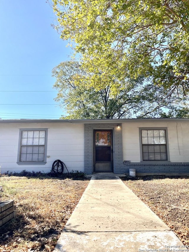 view of exterior entry with brick siding