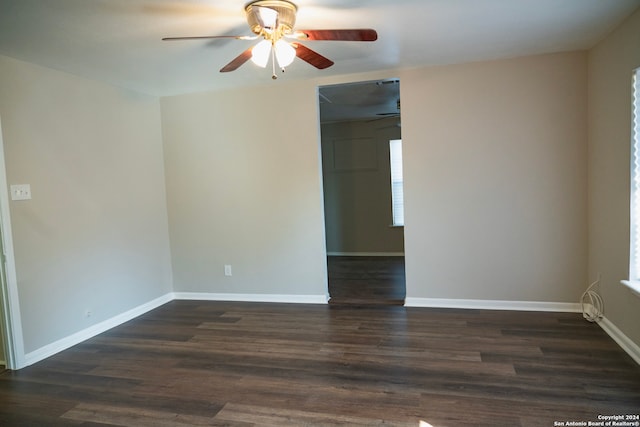 empty room with ceiling fan, dark wood-style floors, and baseboards
