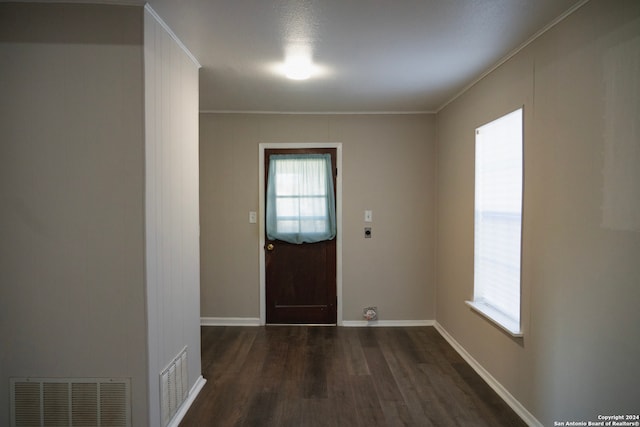 entryway featuring dark wood-style flooring, crown molding, and baseboards