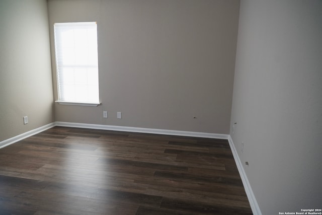 empty room featuring wood finished floors and baseboards