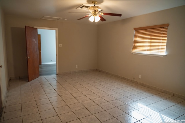 unfurnished room featuring light tile patterned flooring, attic access, and a ceiling fan