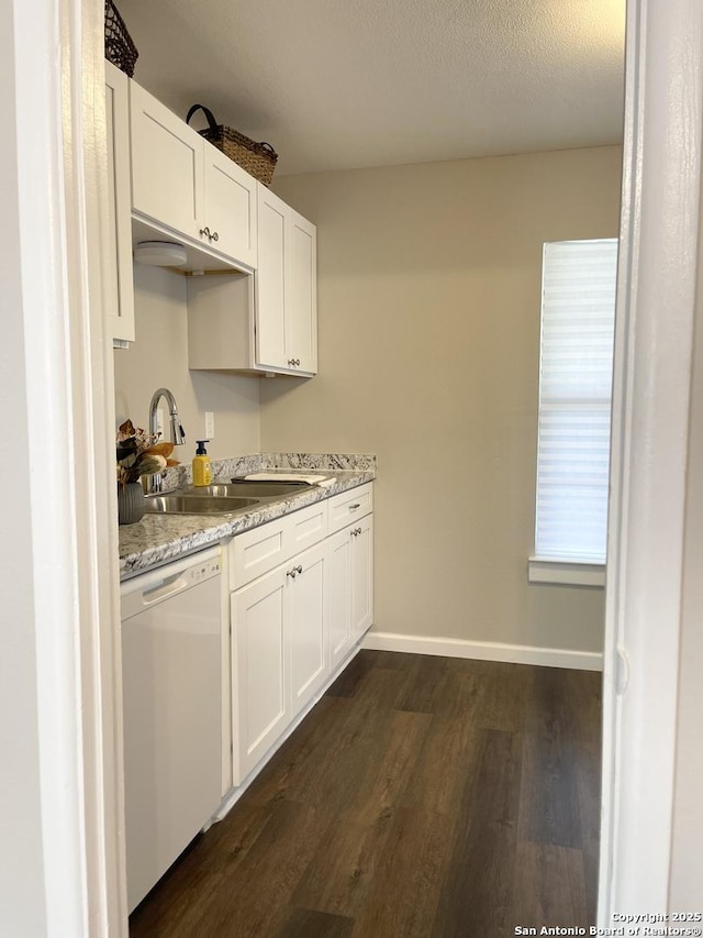 kitchen with dishwasher, a sink, dark wood-style flooring, white cabinetry, and baseboards