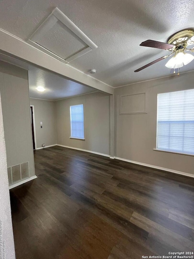 empty room featuring wood finished floors, a ceiling fan, baseboards, and a textured ceiling
