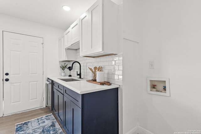 3327 K, San Antonio, TX 78220 - kitchen with a sink, light wood-style flooring, light countertops, tasteful backsplash, and white cabinetry