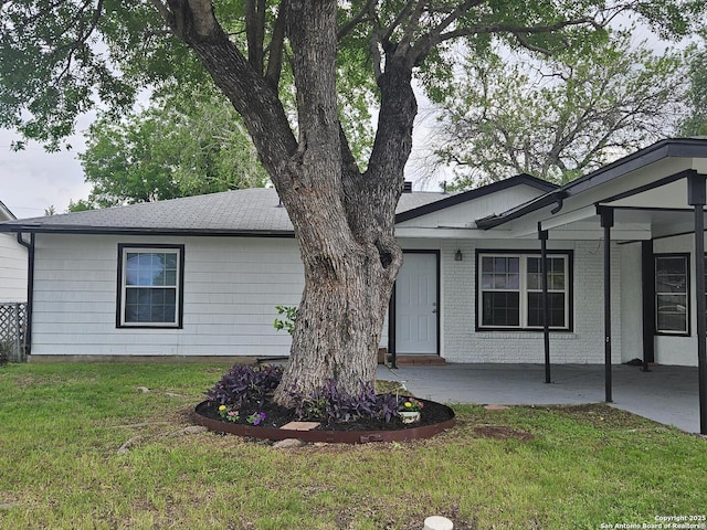ranch-style home with a front yard and a shingled roof