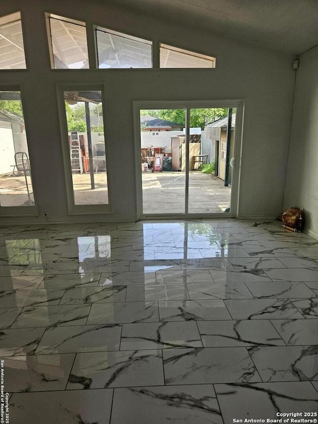 unfurnished room featuring marble finish floors and plenty of natural light