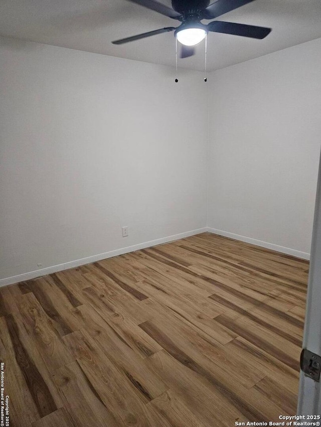 spare room featuring ceiling fan, wood finished floors, and baseboards