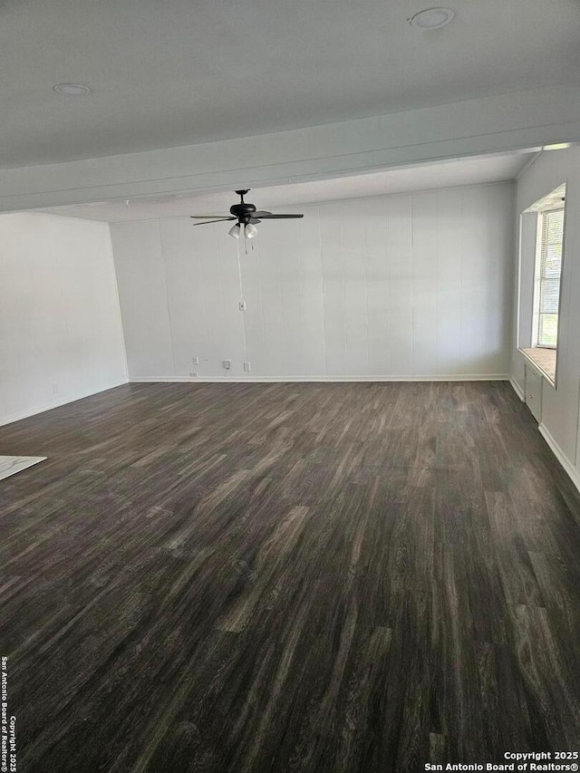 spare room with wood finished floors, a ceiling fan, and baseboards