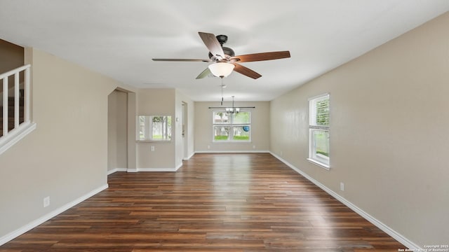 744 Pinehurst, New Braunfels, TX 78130 - unfurnished living room featuring ceiling fan, dark wood-style floors, baseboards, and a chandelier