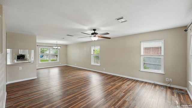 744 Pinehurst, New Braunfels, TX 78130 - unfurnished living room featuring ceiling fan, dark wood-type flooring, baseboards, and a chandelier