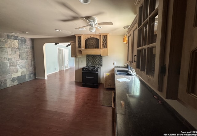6614 Shady Lk, San Antonio, TX 78244 - kitchen with black range with gas stovetop, ceiling fan, a sink, dark wood-type flooring, and arched walkways